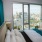 a room with a bed and a window with a view of a city