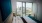 a room with a bed and a window with a view of a city