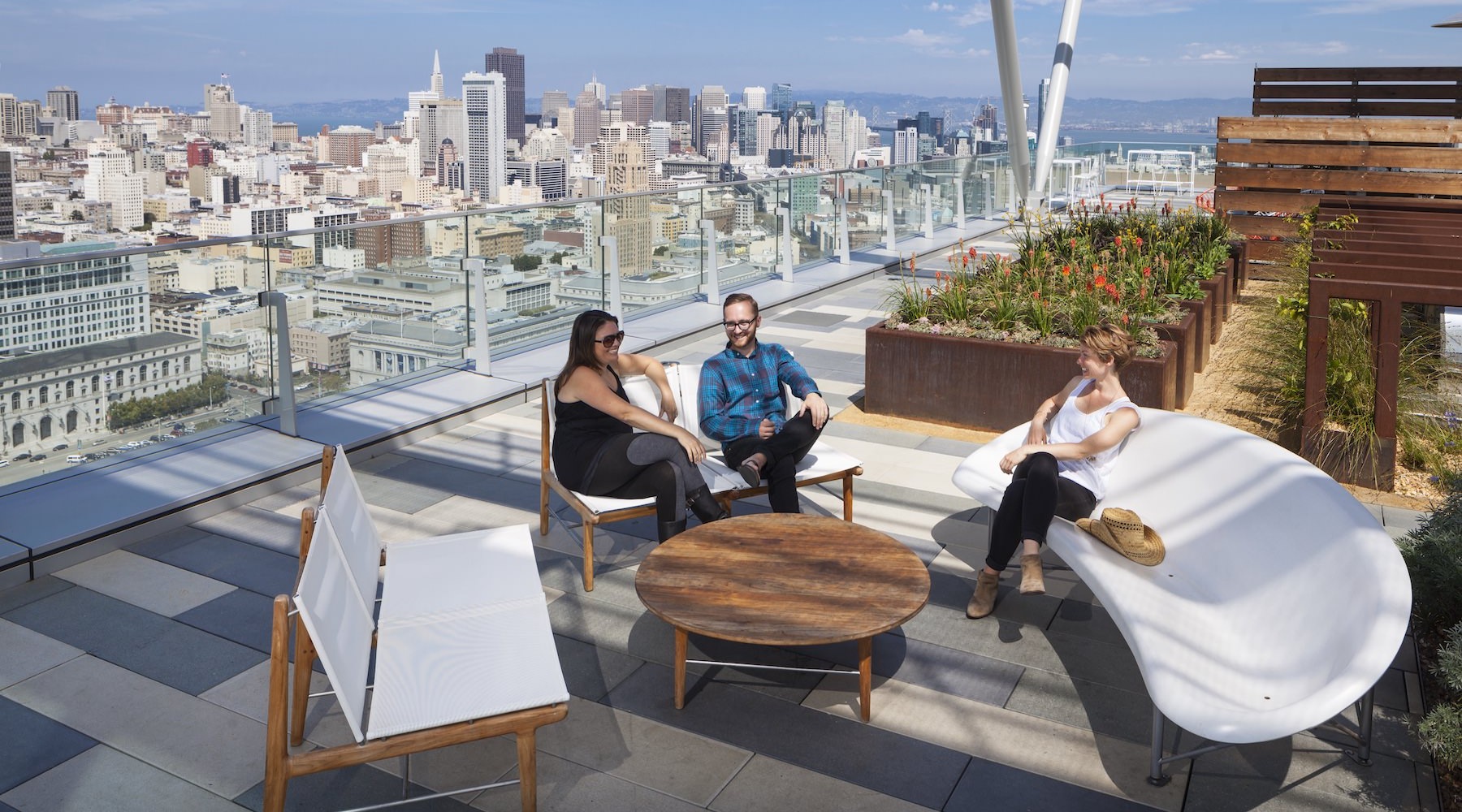 group of people sitting on a rooftop deck 
