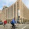 a group of people riding bikes on a street next to a large building