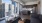 Spacious and well lit living room with wood flooring, large windows and open access to the kitchen