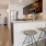a kitchen with stools and a refrigerator