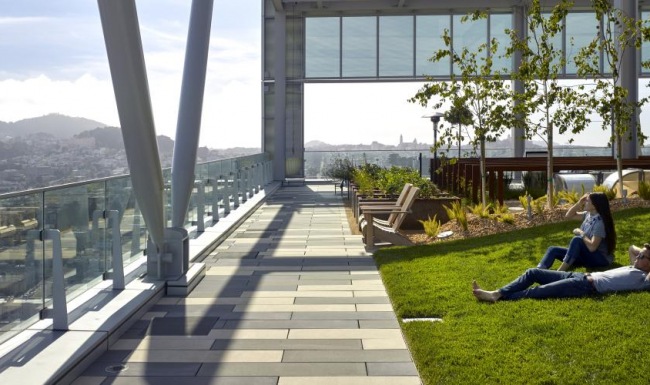a couple of people sitting on the grass by a building